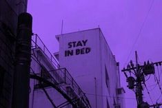 a building with a sign that says stay in bed on it's side and some power lines