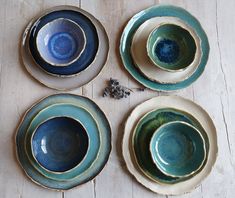 four blue and green plates sitting on top of a wooden table