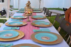 a table set up with blue and gold plates