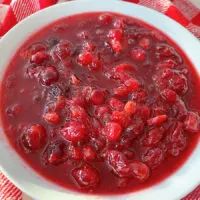 a white bowl filled with cranberry sauce on top of a table