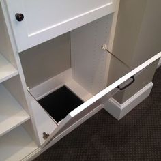 an open white cabinet on the floor in a room