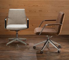 two office chairs sitting side by side on top of a wooden floor next to each other