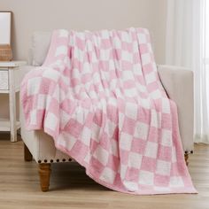 a pink and white checkered blanket sitting on top of a couch