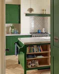 a kitchen with green cabinets and white counter tops