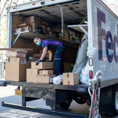 a man unloading boxes from the back of a moving truck