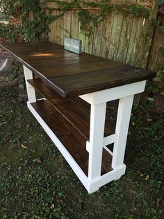 an outdoor table made out of pallet wood and white paint with a sign on top