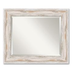 a white framed mirror with an old wood frame and silver trimming on the edges