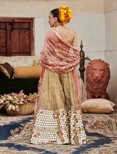 A stunning statement piece, this gold mirror work sharara features intricate mirror embellishments at the bottom, creating a radiant silhouette. Paired with a matching mirror work corset that enhances the ensemble's charm, and a vibrant red dupatta adorned with a mirror border, this outfit beautifully blends opulence with traditional elegance, making it perfect for festive celebrations and special occasions. Luxury Festive Sharara With Mirror Work, Luxury Multicolor Sharara With Mirror Work, Designer Gold Sharara With Mirror Work, Gold Bollywood Sharara With Mirror Work, Gold Sharara With Mirror Work, Gold Corset, Sharara Set, Mirror Work, Indian Ethnic Wear