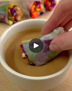 a person dipping some kind of food into a bowl