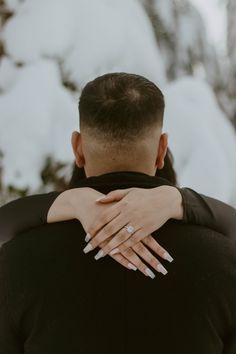 a man and woman embracing each other in the snow