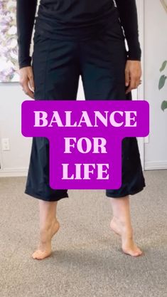 a woman standing in front of a purple sign that says balance for life