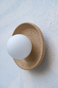 an egg sitting in a wooden bowl on the wall