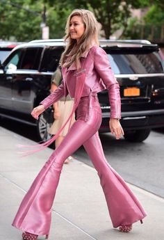 a woman in pink is walking down the street