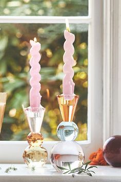 three candles sitting on top of a window sill