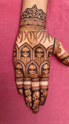 a woman's hand with henna tattoos on it