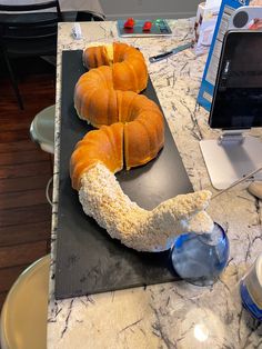 two loaves of bread sitting on top of a counter next to a laptop computer