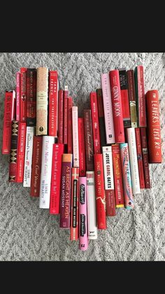 there are many books arranged in the shape of a heart on the carpeted floor