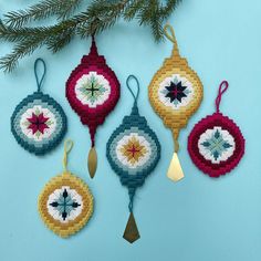 four ornaments hanging from a christmas tree on a blue background