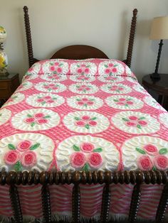 a pink and white bedspread with roses on it