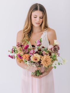 a woman holding a bouquet of flowers in her hands