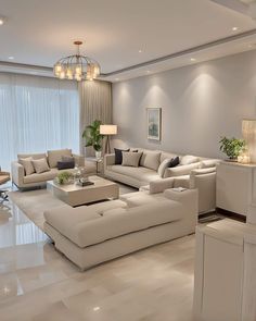 a modern living room with white furniture and large windows in the back ground floor to ceiling curtains