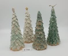 three ceramic christmas trees are shown in front of a white background with a price tag