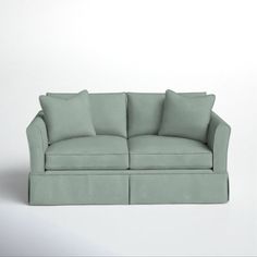 a light green couch sitting on top of a white floor