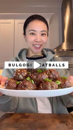 a woman holding a plate with meatballs on it and the words bulogi tabalas in front of her