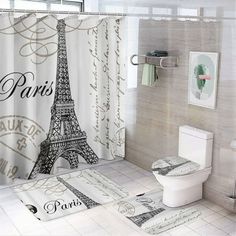 a bathroom with a shower curtain, toilet and rugs in the shape of the eiffel tower