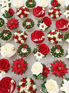 cupcakes decorated with red and white flowers are on display