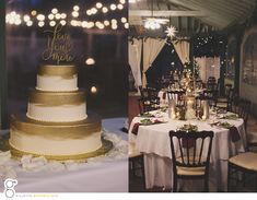 a wedding cake sitting on top of a table covered in white and gold cloths