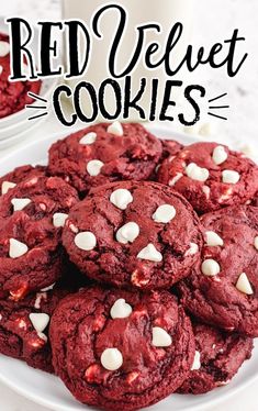 red velvet cookies with white chocolate chips on a plate next to a glass of milk