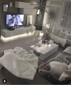 a living room filled with lots of furniture and a flat screen tv mounted on the wall