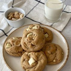 several cookies on a plate next to a glass of milk