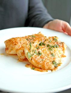 a person holding a white plate with some food on it