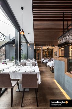 an empty restaurant with white tables and chairs