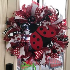 a red and black wreath with a lady bug on it