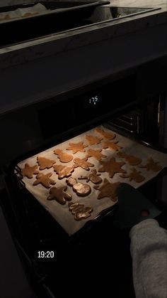 a person is baking ginger cookies in the oven with an oven mitt next to them