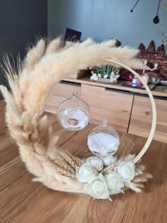 a close up of a wreath on a table with flowers and feathers in the middle