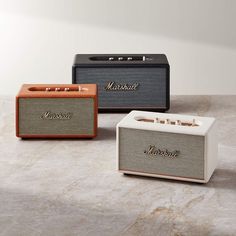 three different types of speakers sitting on top of a marble counter next to each other