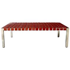 a red table with metal legs on a white background