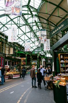 people are walking through an open market area