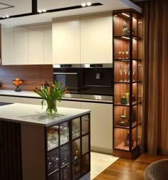 a kitchen with white cabinets and an island in front of the stove top is filled with wine glasses