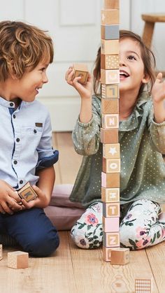 two children playing with wooden blocks on the floor