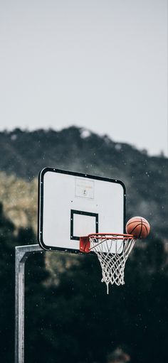 a basketball going through the hoop in front of a mountain