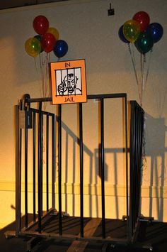 there is a jail cell with balloons in the air and a sign that says it's jail