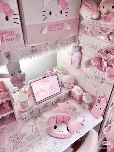 a pink hello kitty themed desk with stuffed animals