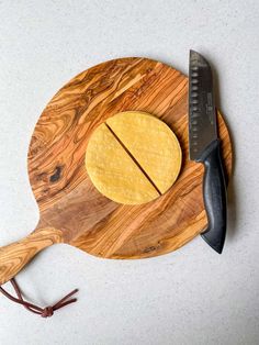 a cutting board with cheese on it next to a knife