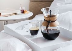 a coffee pot and two cups on a tray