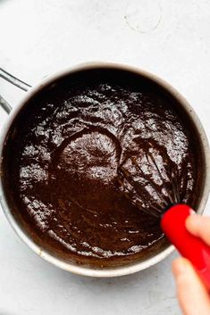 a person is stirring chocolate into a saucepan